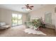 Well-lit bedroom features a ceiling fan, plush carpet, and sliding door access to a balcony at 110 W Yellow Bee Dr, San Tan Valley, AZ 85143