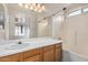 A neutral bathroom featuring a large mirror, vanity with storage, and tub with shower at 11040 W Hayward Ave, Glendale, AZ 85307