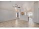 Bright living room featuring neutral tile flooring, an open floorplan, and white walls at 11040 W Hayward Ave, Glendale, AZ 85307