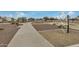 Cement walking path with bench and exercise equipment surrounded by desert landscaping and trees at 11040 W Hayward Ave, Glendale, AZ 85307