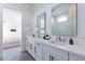 Bathroom with dual sinks, quartz counters, and a view of a bedroom with luxury vinyl floors at 11188 N Blakely St, Surprise, AZ 85388