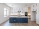 Modern kitchen featuring white cabinetry, stainless steel appliances, and a large island with a marble countertop at 11188 N Blakely St, Surprise, AZ 85388