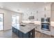 Modern kitchen featuring white cabinetry, stainless steel appliances, and a large island with a marble countertop at 11188 N Blakely St, Surprise, AZ 85388