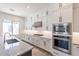 Modern kitchen featuring white cabinetry, stainless steel appliances, and a large island with a marble countertop at 11188 N Blakely St, Surprise, AZ 85388