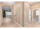 Hallway with archway leading to a living area with plantation shutters and neutral walls at 11915 S 184Th Ave, Goodyear, AZ 85338