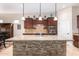 A kitchen island featuring a granite countertop and brick-style facade stands as a focal point at 11915 S 184Th Ave, Goodyear, AZ 85338