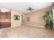 Neutral-toned living area with tile flooring, complemented by a cabinet and a large plant at 11915 S 184Th Ave, Goodyear, AZ 85338