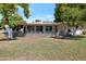 View of the home's exterior with solar panels, a covered patio, mature citrus trees, and a well-maintained lawn at 13620 N Hawthorn Dr, Sun City, AZ 85351