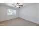 Light-filled bedroom with neutral carpet, ceiling fan, and window view at 13620 N Hawthorn Dr, Sun City, AZ 85351