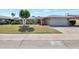 Charming home featuring a well-manicured lawn, mature trees, and an attached two-car garage, creating a welcoming curb appeal at 13620 N Hawthorn Dr, Sun City, AZ 85351