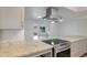 Modern kitchen featuring stainless steel appliances, a cooktop island, and stylish white cabinets at 13620 N Hawthorn Dr, Sun City, AZ 85351