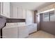 Functional laundry room with washer, dryer, and built-in storage cabinets at 13620 N Hawthorn Dr, Sun City, AZ 85351