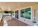 View of the tile-floored covered patio including a hot tub, TV, and outdoor table set adjacent to the sliding glass doors at 13620 N Hawthorn Dr, Sun City, AZ 85351