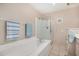 Bright bathroom featuring a soaking tub and glass-enclosed shower at 15227 N Rosewood Dr, Sun City, AZ 85351