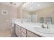 Bathroom featuring double sinks, ample countertop space, and a glass-enclosed shower at 15227 N Rosewood Dr, Sun City, AZ 85351