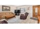 Cozy living room featuring a comfortable sofa, leather recliner, and an attractive hardwood door at 15227 N Rosewood Dr, Sun City, AZ 85351