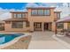 An exterior backyard view of a two-story home with a pool, patio, and desert landscaping at 15322 W Montecito Ave, Goodyear, AZ 85395