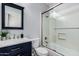 Updated bathroom with a navy blue vanity, marble countertop, and a shower with glass doors at 15322 W Montecito Ave, Goodyear, AZ 85395