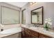 The bathroom features granite countertops, dual sinks, a soaking tub, and a view of the neighborhood at 15322 W Montecito Ave, Goodyear, AZ 85395