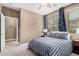 Cozy bedroom features a ceiling fan and an ensuite bathroom with a neutral color palette and natural light at 15322 W Montecito Ave, Goodyear, AZ 85395