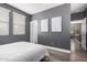 Bedroom with luxury vinyl plank flooring, gray accent wall and entryways to a closet and hallway at 15322 W Montecito Ave, Goodyear, AZ 85395