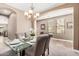 Bright dining area featuring a glass table, neutral colors, and a modern chandelier at 15322 W Montecito Ave, Goodyear, AZ 85395