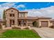 Beautiful two-story home with a lush front lawn, a stone facade, and a spacious three-car garage at 15322 W Montecito Ave, Goodyear, AZ 85395