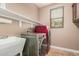 A laundry room featuring a washer, dryer, utility sink, and open shelving at 15322 W Montecito Ave, Goodyear, AZ 85395