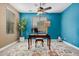 Vibrant blue office featuring desk, decorative rug, and a large houseplant at 15322 W Montecito Ave, Goodyear, AZ 85395