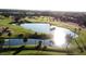 Scenic aerial view of the community golf course with manicured green lawns, water features, and palm trees at 15881 W Berkeley Rd, Goodyear, AZ 85395