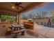 Covered outdoor kitchen and dining area, situated near a pool, create an ideal entertainment space at 15881 W Berkeley Rd, Goodyear, AZ 85395