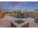 Expansive backyard featuring a sparkling pool, built-in fire pit, and desert landscaping at 15881 W Berkeley Rd, Goodyear, AZ 85395