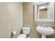 Powder room with pedestal sink, mirror, and a toilet at 15881 W Berkeley Rd, Goodyear, AZ 85395