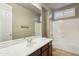 Bathroom features a large mirror, vanity with brown cabinets, and a shower over the bathtub at 15881 W Berkeley Rd, Goodyear, AZ 85395