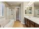 This primary bathroom features a double vanity, soaking tub, and glass-enclosed shower for a spa-like experience at 15881 W Berkeley Rd, Goodyear, AZ 85395