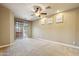 Spacious carpeted bedroom featuring a ceiling fan and sliding door access to the backyard at 15881 W Berkeley Rd, Goodyear, AZ 85395