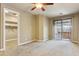 Spacious carpeted bedroom featuring a ceiling fan, walk-in closet, and sliding door access to the backyard at 15881 W Berkeley Rd, Goodyear, AZ 85395