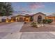 Beautiful single-story home features a tile roof and desert landscaping at dusk at 15881 W Berkeley Rd, Goodyear, AZ 85395