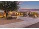 Charming single-story home with desert landscaping, tile roof, and two-car garage at dusk at 15881 W Berkeley Rd, Goodyear, AZ 85395