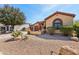 Single-story home with a two-car garage and beautiful desert landscaping with gravel, plants, and rock features at 15881 W Berkeley Rd, Goodyear, AZ 85395