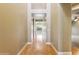 Hallway with hardwood floors leading to the living room with lots of natural light at 15881 W Berkeley Rd, Goodyear, AZ 85395