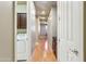 Hallway with wood floors, leading to a laundry room and another room with dark cabinets at 15881 W Berkeley Rd, Goodyear, AZ 85395