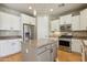 Well-lit kitchen with stainless steel appliances, island, and pendant lighting at 15881 W Berkeley Rd, Goodyear, AZ 85395