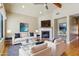 Bright living room with fireplace, white sofas, hardwood floors, and neutral paint at 15881 W Berkeley Rd, Goodyear, AZ 85395