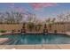 Backyard pool with stone waterfall features and mature landscaping, creating a relaxing retreat at 15881 W Berkeley Rd, Goodyear, AZ 85395