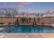 Backyard pool with stone waterfall features and mature landscaping, creating a relaxing retreat at 15881 W Berkeley Rd, Goodyear, AZ 85395