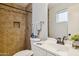 Bathroom featuring tiled shower with built-in niche, toilet, vanity, and decorative accents at 1747 W Belfast St, Mesa, AZ 85201