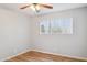 Bedroom featuring wood-look floors, a ceiling fan, and a window offering natural light at 1747 W Belfast St, Mesa, AZ 85201