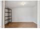 An empty room with laminate floors, wire shelving and white walls with electrical outlets at 1747 W Belfast St, Mesa, AZ 85201