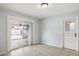 Tiled living room featuring neutral walls, sliding glass door to back patio, and a side door at 1747 W Belfast St, Mesa, AZ 85201